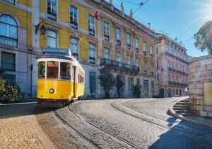 Famous vintage yellow tram 28 in the narrow streets of Alfama district in Lisbon, Portugal