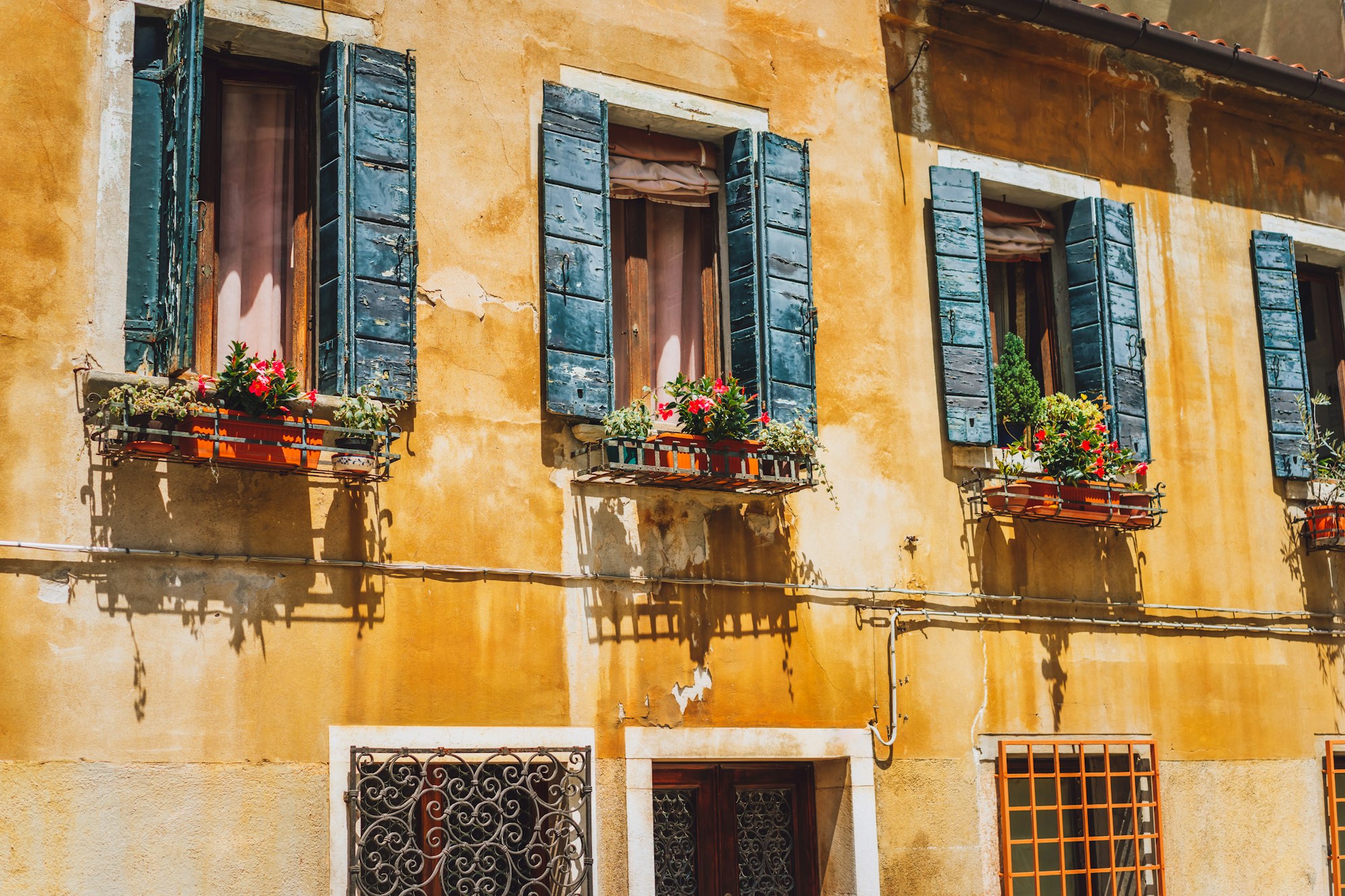 Venice old yellow facade of house with wood windows on the street in Venice Italy